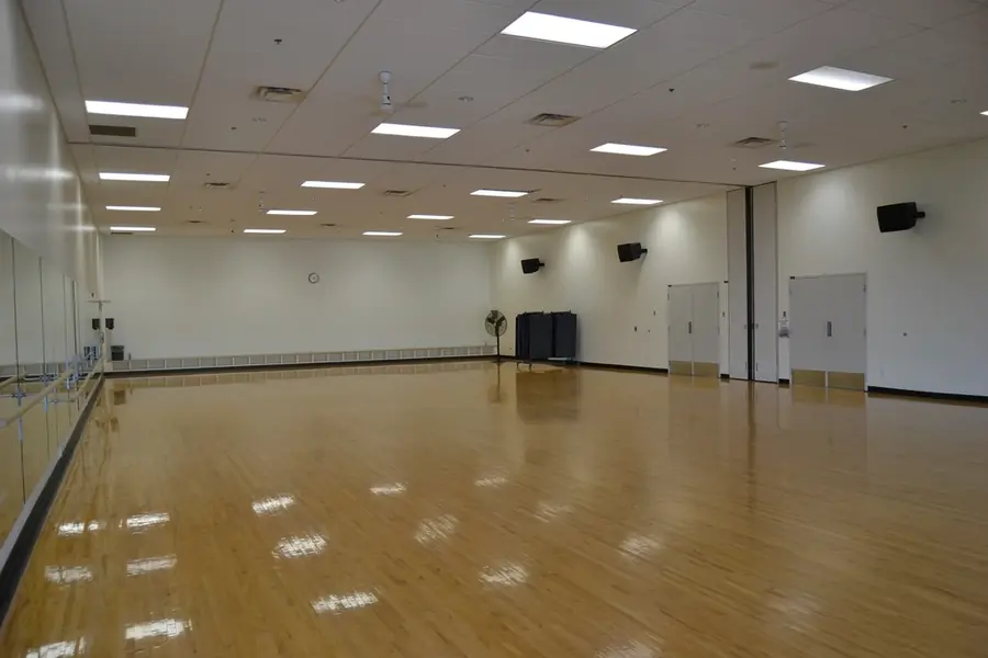 Pavilhão desportivo claro com piso de madeira envernizada